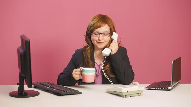 Junge Betreuerin im Büro telefoniert und trinkt Tee — Stockvideo