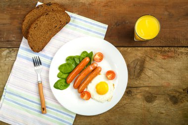 Çırpılmış yumurta ve güneş şeklinde sosis. Kahvaltıda bir bardak meyve suyu..