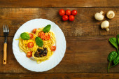 Картина, постер, плакат, фотообои "plate of pasta nests stuffed with assorted pasta paste, cheese with cherry and fried mushrooms next to vegetables.", артикул 387009552