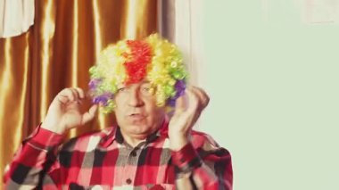 Karnaval peruğuyla çok renkli buklelerle dans eden bir adam..