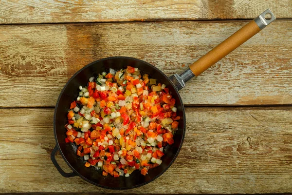 On a wooden table, a pan with frozen vegetables fast food. — Stock Photo, Image