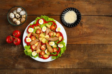 Çeri domatesli Pan-Asya salatası, tütsülenmiş tavuk, ananas ve susam tohumları ve ahşap bir masa üzerinde çeşitli malzemeler..