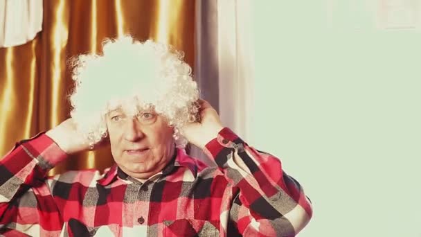 Un uomo sta ballando in una parrucca di carnevale con riccioli bianchi. — Video Stock