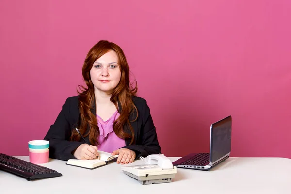 Молода жінка в офісі за столом з щоденником . — стокове фото