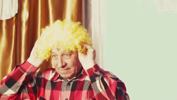 En man dansar i en karneval peruk med gula lockar — Stockvideo