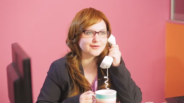 Young woman supervisor in the office speaks on the phone and drinks tea — Stock Video