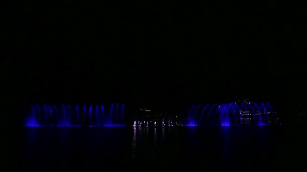 Multi-colored fountains on the water against the background of the night sky with different combinations of fire show elements. — Stock Video