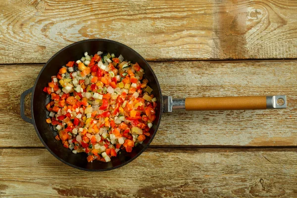 На деревянном столе кастрюля с замороженными овощами для приготовления пищи . — стоковое фото