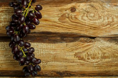 Tahta bir masada koyu sulu üzümler..