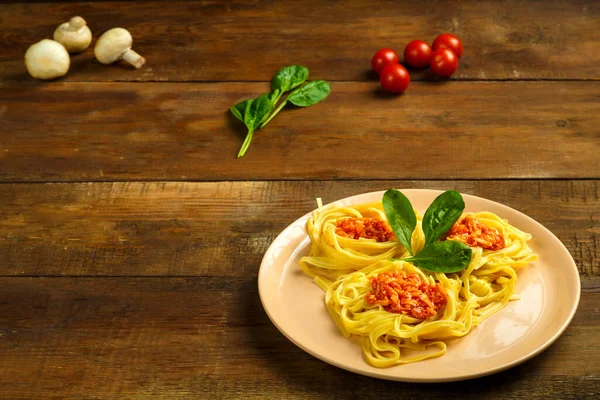 Sebzelerin yanında domates ezmesi ve sebze ile doldurulmuş makarnanın üzerindeki tabak..