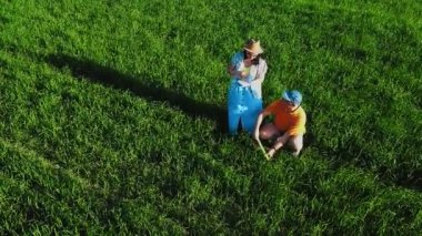 Tarladaki bir adam ve bir kadın tarladaki tarlaları ve gözlemleri inceliyor.