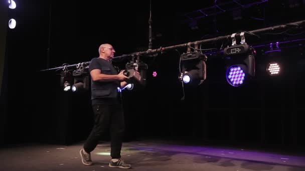 Een mannelijke lichtwerker hangt een watergenerator op een watertank met soffits — Stockvideo