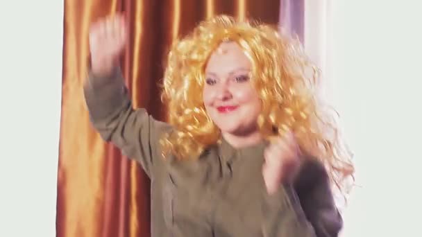 Молода жінка танцює в карнавальній перуці із золотим волоссям . — стокове відео