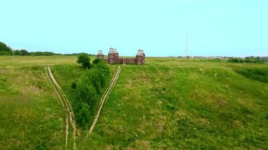 Uzaktan yüksek bir tepede duran ahşap bir kale..