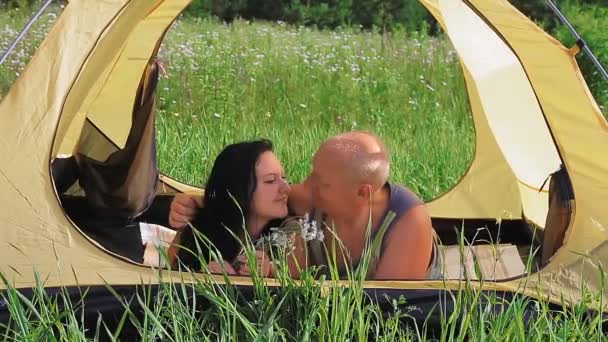 Dans une tente le matin sur la nature, un couple de graines étreint. — Video