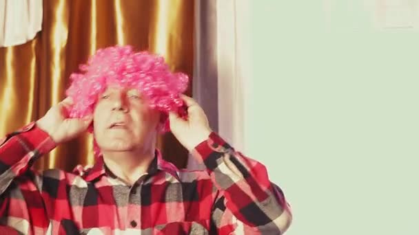 Un homme danse dans une perruque de carnaval avec des boucles roses — Video