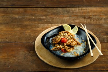 Funselli tabak ve sebzeli tavuk. Tayland sosu, yemek çubuklarının yanında..