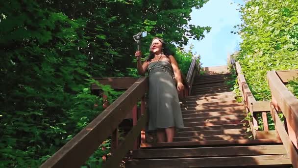 Blogueuse femme avec téléphone portable sur les voyages parle des vieux escaliers. — Video
