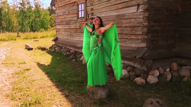 Joodse vrouw in een pak voor buik dansen op een steen fladderen sjaal in de natuur — Stockvideo