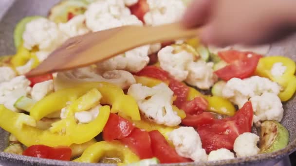 Remover las verduras fritas en una sartén con una espátula . — Vídeo de stock