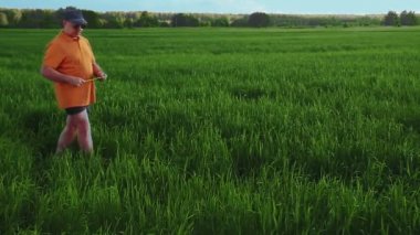 Tarladaki tarımcı adam ekinlerin parametrelerini ölçer..