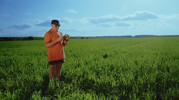 Hombre agrónomo en el campo mide los parámetros de los cultivos — Vídeos de Stock