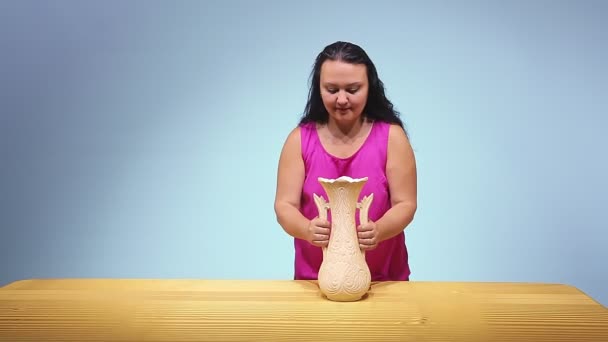 La femme verse des pièces d'une grande cruche sur la table. — Video