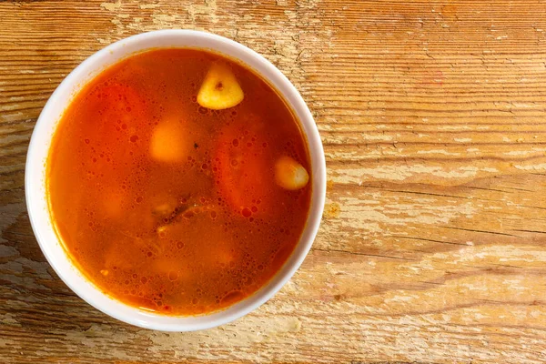 Traditionelle thailändische Tom-Yam-Suppe in einem Teller auf einem Holztisch. Kopierraum. — Stockfoto