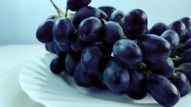 Plate with grapes and peaches rotates in a circle on a white background. — Stock Video