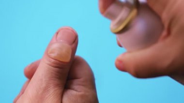 Krema ilacı mavi arka plandaki bir parmak yanığının kabarcığına uygulanır. Ortalama plan