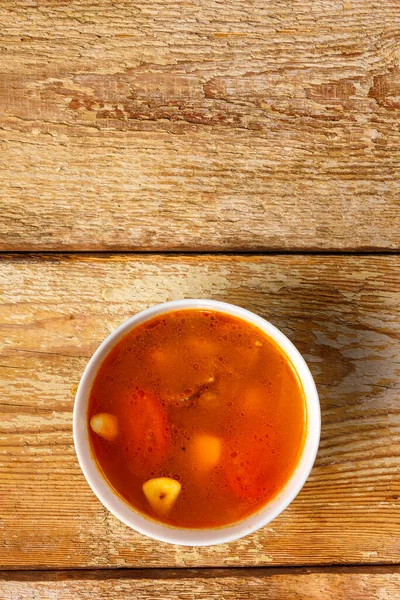 Hagyományos thai Tom Yam leves egy tányéron egy fa asztalon. Másold le a helyet.. — Stock Fotó