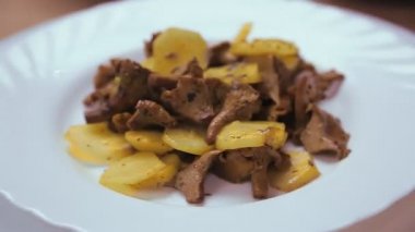 Beyaz tabakta mantarlı kızarmış patates..