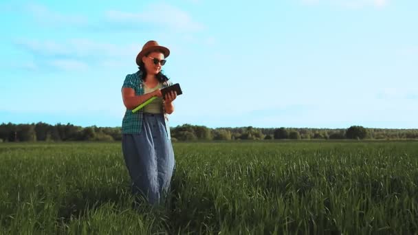 Agronomistas uma mulher em um campo inspeciona colheitas — Vídeo de Stock