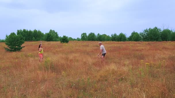 Un hombre y una mujer de vacaciones jugando al bádminton en el prado. Vueltas de tiempo — Vídeos de Stock