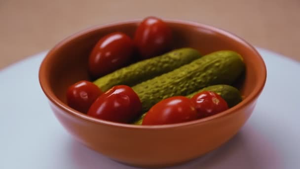 Nakládané okurky a rajčata v hliněném talíři. — Stock video
