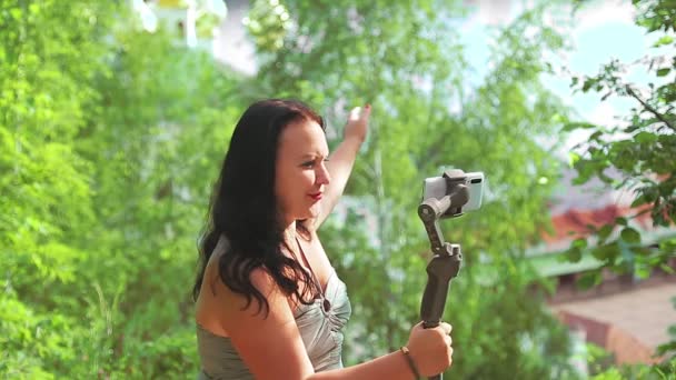 Una mujer bloguea desde su teléfono móvil sobre viajes y habla sobre el templo visto desde la montaña — Vídeos de Stock