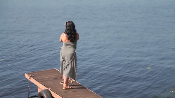 Een vrouw blogger met een mobiele telefoon is bloggen door de rivier. — Stockvideo