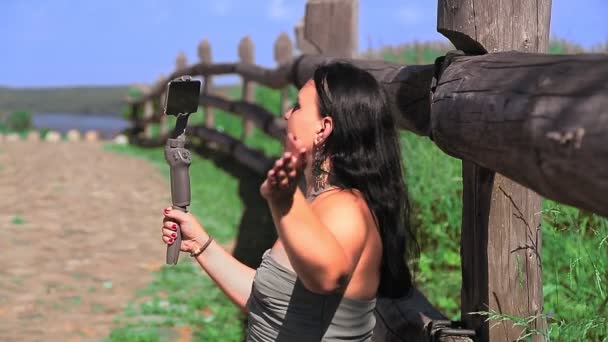Женщина-блогер транслирует с горной вершины с видом на реку — стоковое видео