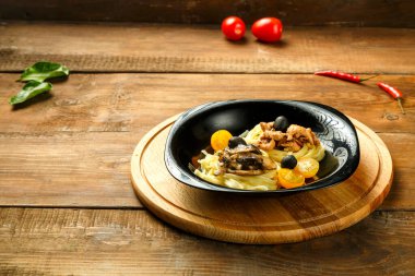 Köfteli tavuk filetosu ve mantarla doldurulmuş spagetti yuvalı siyah tabak. Boşluğu kopyala