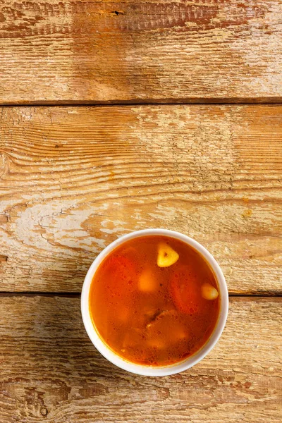 Традиционный тайский суп Том Ям в тарелке на деревянном столе. Скопируйте место.. — стоковое фото