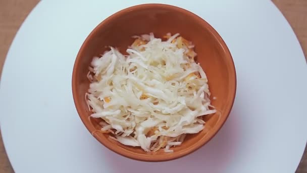 Pickled cabbage with carrots in a clay plate. — Stock Video