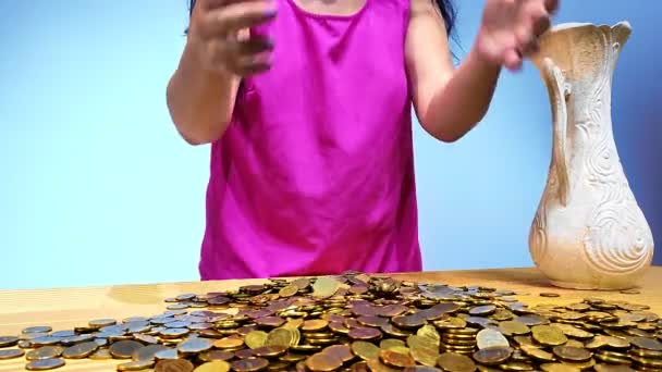 Žena vylévá mince roztroušené po stole ve svých rukách. — Stock video