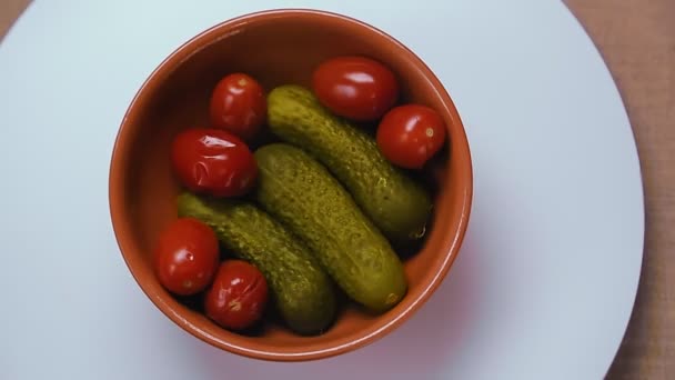 Pepinos conservados em escabeche e tomates em uma chapa de barro . — Vídeo de Stock