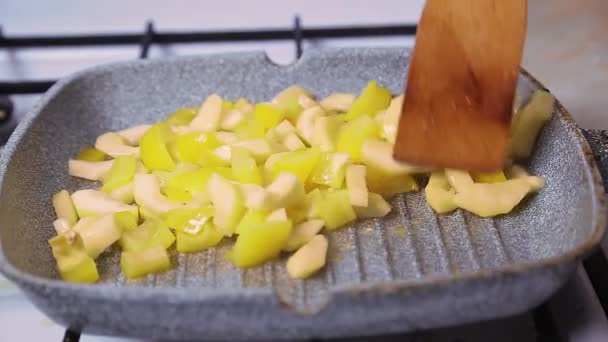 Roer de gesneden courgette in een koekenpan met een houten spatel. — Stockvideo