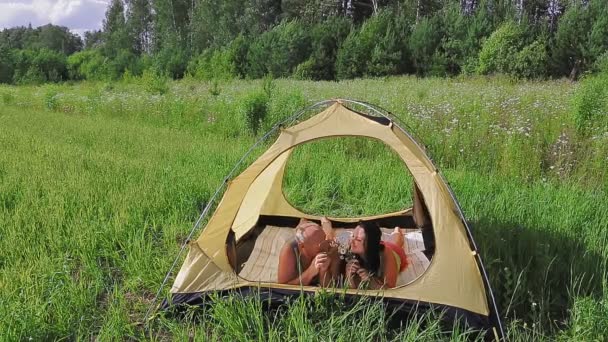 I ett tält på morgonen utomhus smeker paret varandra.. — Stockvideo