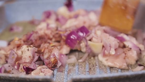 Uma espátula mistura o filete de frango frito com a cebola em uma panela . — Vídeo de Stock