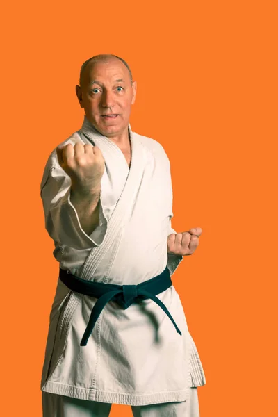 A karate man in a white kimono with a black belt is training. — Stock Photo, Image