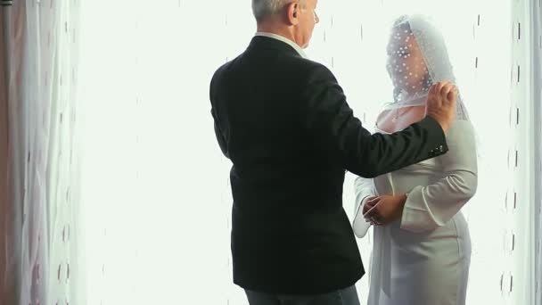 The Jewish groom approaches the bride, throws the veil from her face and kisses her. — Stock Video