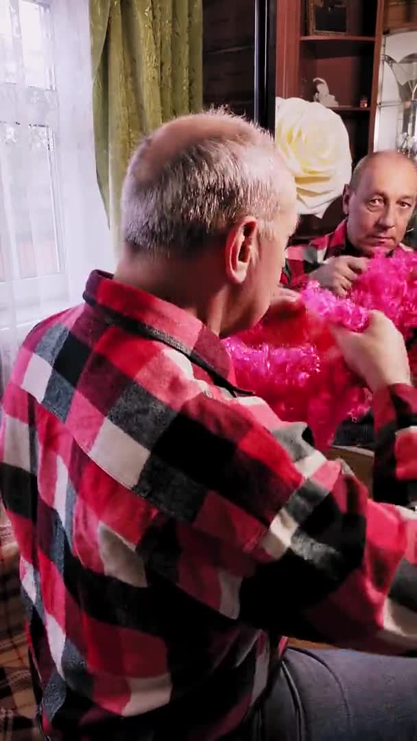 Man animator zet op een clown roze pruik in de voorkant van een spiegel. Verticale video — Stockvideo