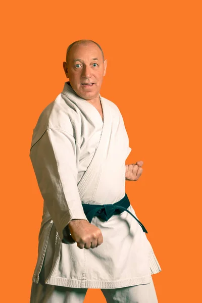 A karate man in a white kimono with a black belt makes kata. — Stock Photo, Image
